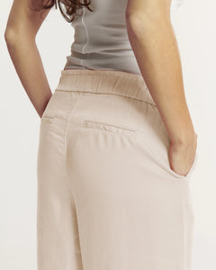 Pantalon femme beige clair en tissu Tencel doux et fluide, coupe droite avec taille élastiquée, offrant un ajustement confortable et élégant pour toutes morphologies.