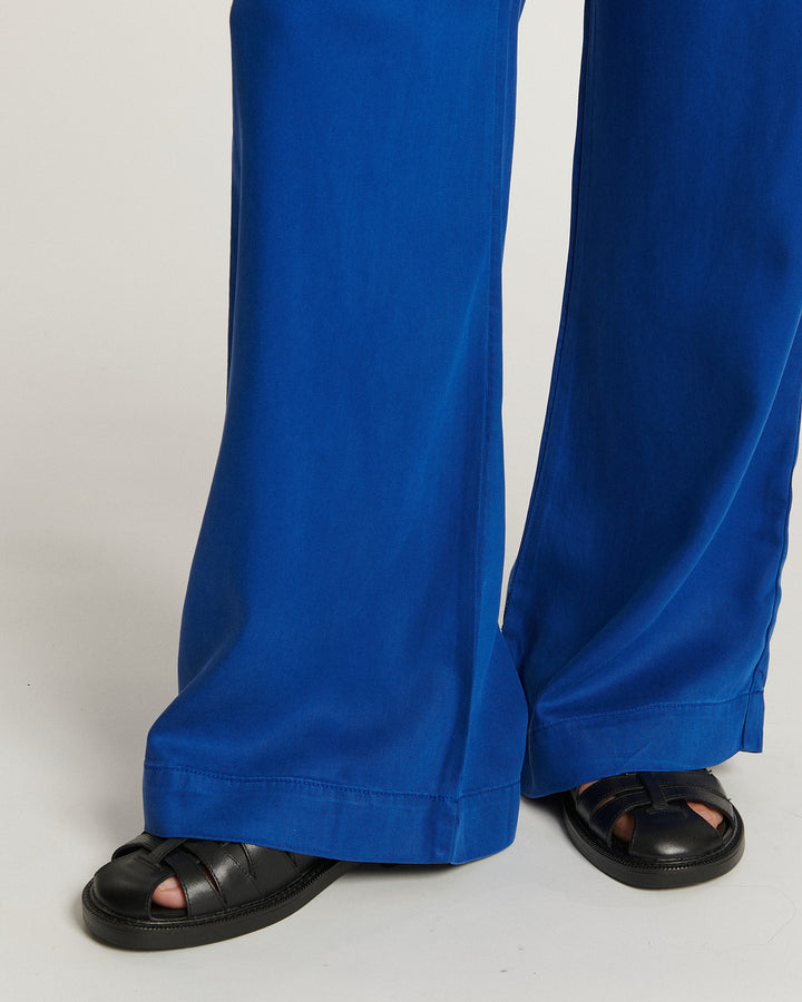 Jean femme en tissu tencel bleu outremer, coupe large et fluide, légèrement évasée au bas, offrant un confort estival et un style décontracté élégant.