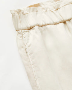 Détail d’un pantalon en tissu Tencel couleur écume, coupe droite avec ceinture élastique, finition douce et légère, idéal pour l’été au style décontracté.