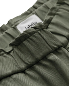 Détail d’un pantalon en tissu tencel kaki avec une taille élastiquée et une coupe confortable, idéal pour un jean femme alliant douceur et style décontracté.