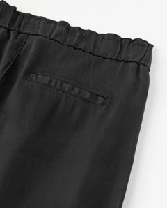 Pantalon noir en tencel fluide avec taille élastiquée et coupe droite, conçu pour s’adapter à toutes les morphologies féminines.