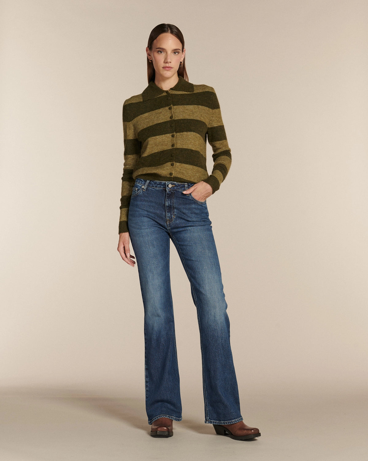 Jean femme en denim bleu moyen à effet légèrement délavé, coupe flare ajustée à la taille et évasée aux jambes, offrant un ajustement confortable et élégant.
Porté par le mannequin de face