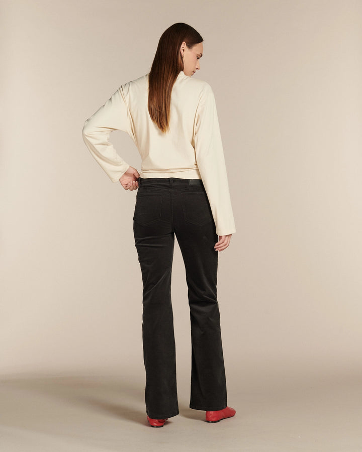 Jean noir en denim 100 % coton avec coupe flare légèrement évasée et taille haute, offrant une silhouette élégante qui s’adapte à toutes les morphologies.