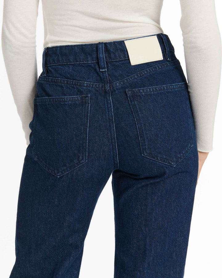 Jean en denim brut bleu foncé, coupe droite légèrement ample, confectionné en coton épais, offrant un ajustement confortable et adapté à toutes les morphologies.