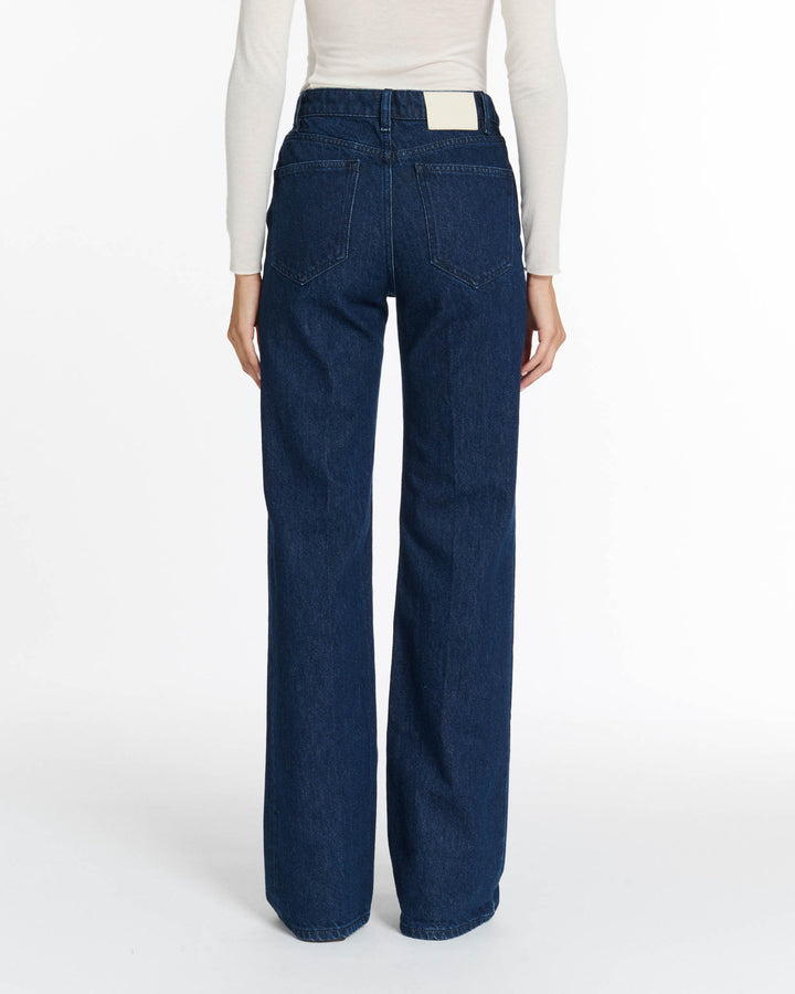 Jean droit en denim brut bleu foncé, coupe féminine et intemporelle, confectionné en coton 100 % pour un confort optimal et adapté à toutes les morphologies.