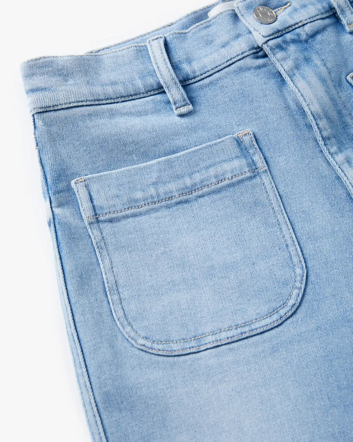Jean en denim bleu clair, coupe droite avec tissu 100 % coton, offrant un tombé souple et une texture légèrement délavée pour un style estival féminin.