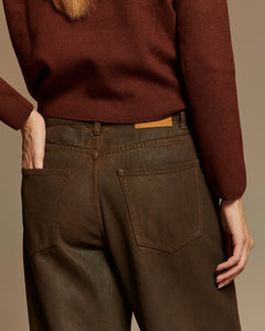 Jean femme en denim 100% coton marron glossy avec coupe ballon, taille moyenne, et finition lisse légèrement brillante adaptée à toutes morphologies.