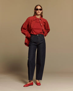 Jean droit en denim brut 100% coton avec une coupe haute qui s’adapte aux morphologies féminines, offrant un style épuré et confortable.
Porté par le mannequin de face