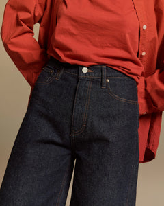 Jean en denim 100% coton brut, coupe barrel ample et taille haute, avec des surpiqûres contrastantes, idéal pour toutes morphologies.
Porté par le mannequin de face