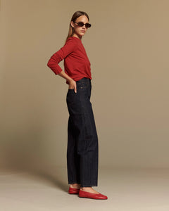 Jean femme en denim brut 100% coton, coupe droite et taille haute, adapté à toutes les morphologies, couleur indigo foncé avec finition raw.
Porté par le mannequin de profil