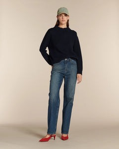 Jean droit en denim bleu moyen avec légère décoloration, coupe classique ajustée à la taille et aux hanches, tissu en coton confortable, idéal pour femme.