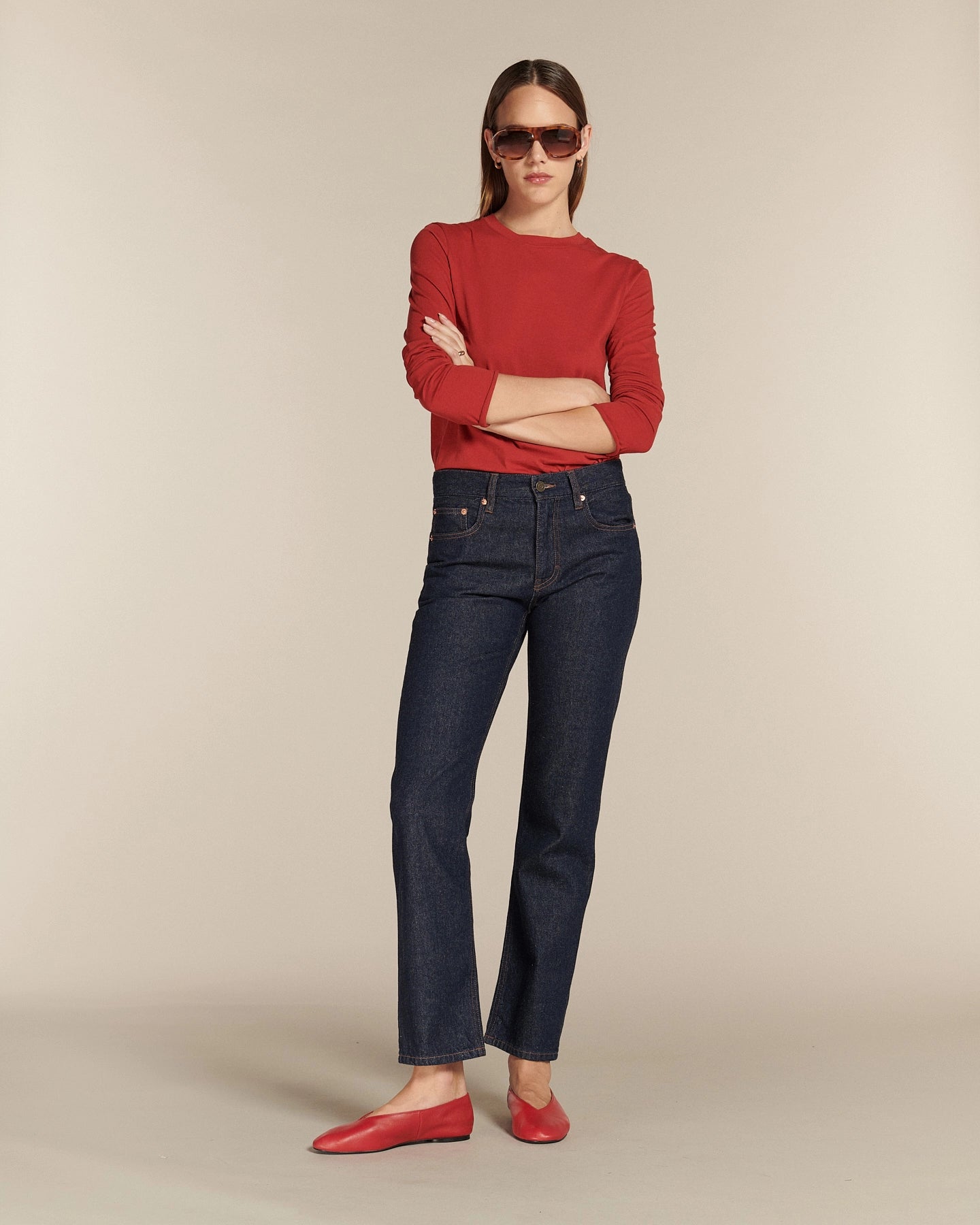 Jean droit en denim bleu foncé 100 % coton avec une coupe ajustée au niveau des hanches et des cuisses, offrant un style intemporel et une silhouette élancée.
