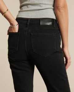 Jean femme en denim noir charbon, coupe droite ajustée, matière coton épaisse et confortable, s’adaptant à toutes les morphologies pour un style intemporel.