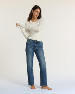 Jean droit en denim bleu moyen avec une coupe ajustée et taille moyenne, conçu en coton 100% pour un confort optimal et une silhouette féminine élégante.