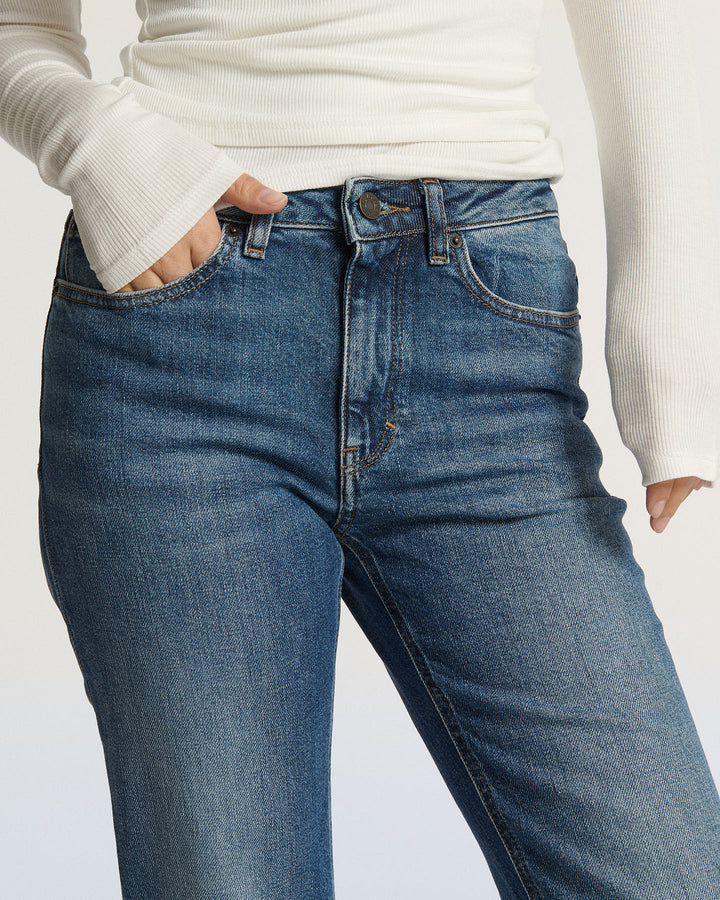 Jean droit en denim bleu moyen avec coupe ajustée, matière 100% coton confortable, idéal pour femme recherchant un pantalon facile à porter et polyvalent.