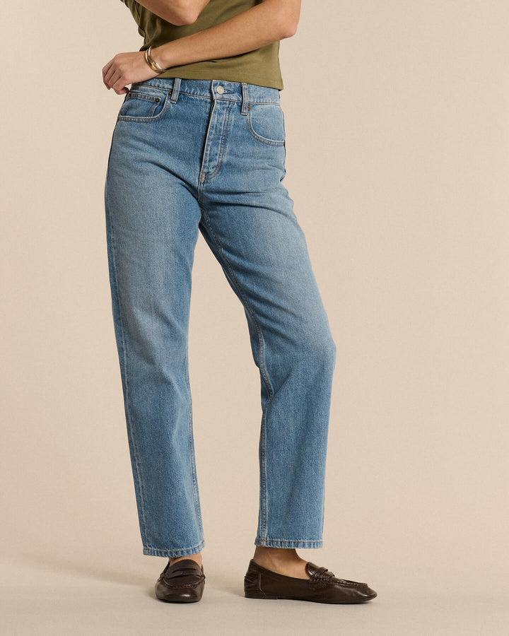 Jean en denim bleu stone fade clair, coupe droite et taille mi-haute, conçu pour un confort optimal et s’adaptant à toutes les morphologies féminines.