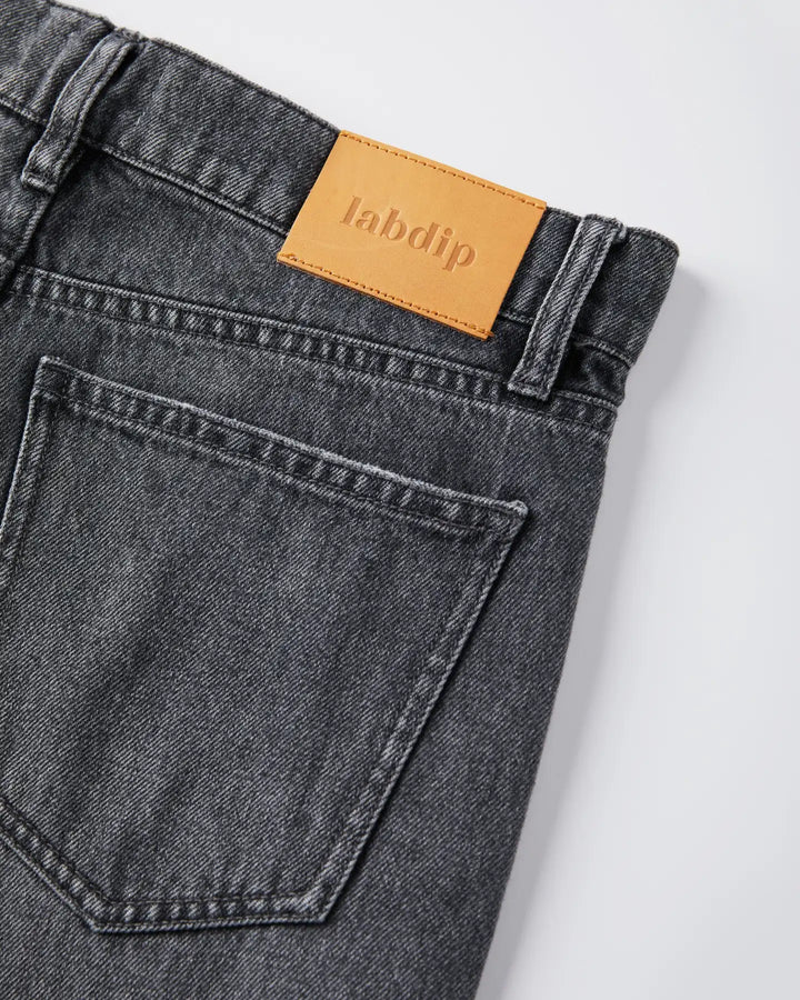 Jean femme en denim 100 % coton de couleur gris poussiéreux, coupe droite avec poche arrière classique et étiquette en cuir beige marqué Labdip.