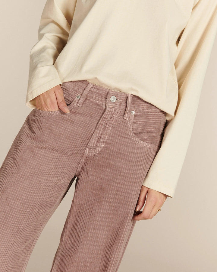 Pantalon femme en velours côtelé couleur vieux rose, coupe droite et ajustée, tissu doux avec texture côtelée verticale, style décontracté et confortable.