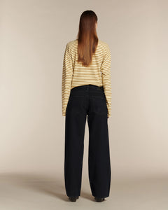 Jean large noir en denim 100 % coton avec coupe boyfriend et taille moyenne, offrant un tombé fluide et confortable adapté à toutes les morphologies féminines.
porté par le mannequin de dos