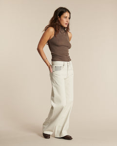 Jean large en denim brut écru avec coupe droite, taille haute, fabriqué en coton, offrant confort et style décontracté pour femme.
Porté par le mannequin de face