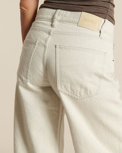 Jean en denim 100% coton de couleur granit naturel non teint, coupe droite légèrement large, confortable et adapté à toutes les morphologies féminines.
Porté par le mannequin de dos