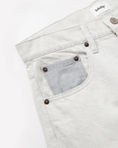 Jean femme en denim 100 % coton non teinté, couleur granit clair avec poche avant contrastée, coupe droite et ajustée, matière robuste et confortable.