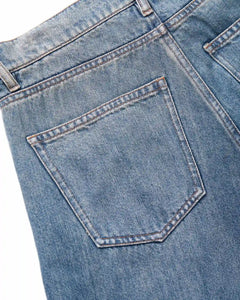 Jean en denim bleu clair avec poche arrière droite, coupe droite et tissu Tencel souple pour un ajustement confortable et élégant.