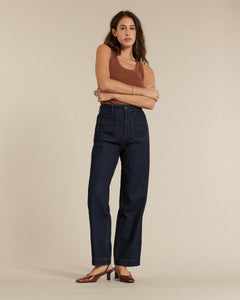 Jean droit en denim brut 100 % coton, coupe ajustée à la taille avec jambes larges, offrant un style sobre et confortable pour toutes les morphologies féminines.