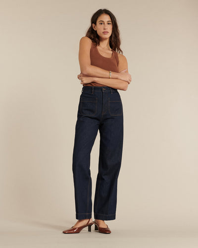 Jean droit en denim brut 100 % coton, coupe ajustée à la taille avec jambes larges, offrant un style sobre et confortable pour toutes les morphologies féminines.