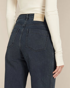 Jean 100 % coton de couleur bleu foncé avec coupe droite et taille haute, offrant un ajustement confortable et élégant pour toutes les morphologies.