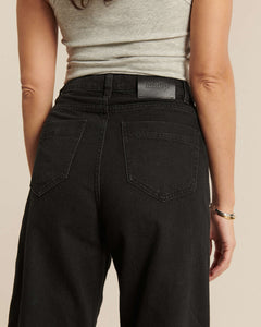 Jean en denim noir foncé 100% coton avec coupe large et taille haute, conçu pour s’adapter à toutes les morphologies féminines avec confort et style.
