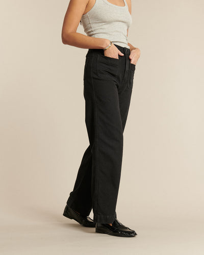 Jean droit en denim noir foncé, coupe classique et confortable, conçu pour épouser toutes les morphologies féminines avec un tissu en coton de qualité.