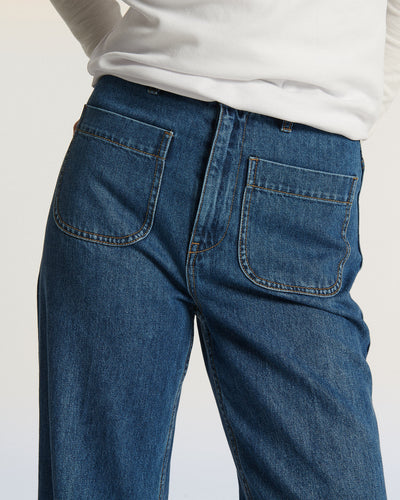 Jean en denim bleu moyen avec coupe droite et poches avant plaquées, conçu pour épouser toutes les morphologies féminines avec confort et élégance.