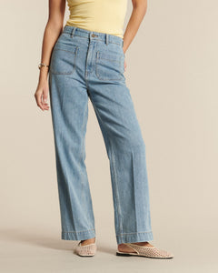 Jean femme en denim coton bleu clair, coupe droite et ample avec poches plaquées, conçu pour s’adapter à toutes les morphologies.