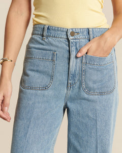 Jean femme en denim bleu clair 100% coton avec coupe droite confortable et poches plaquées devant, idéal pour un style décontracté et moderne.
