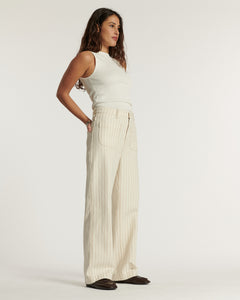 Jean pour femme en coton léger couleur sable à fines rayures, coupe large et ample, offrant un confort estival et une silhouette décontractée adaptable à toutes les morphologies.