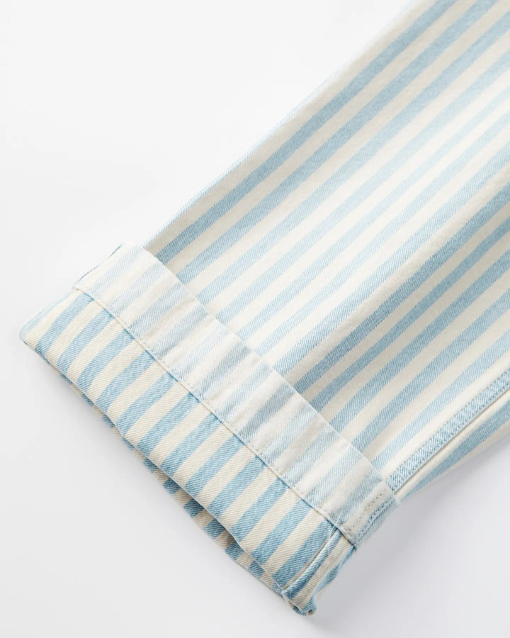 Détail bas de jean en denim léger rayé bleu ciel et blanc, coupe droite avec un ourlet cousu soigné, adapté à toutes les morphologies féminines.