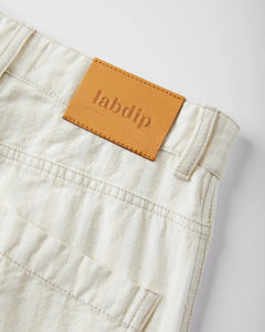 Jean en denim couleur sable clair, 100 % coton, coupe droite avec ceinture et étiquette en cuir camel, idéal pour femme et adapté à toutes les morphologies.