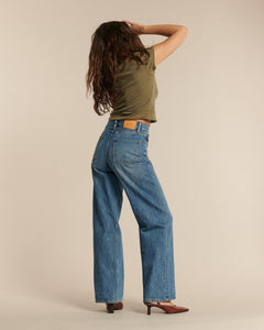 Jean femme en denim bleu milieu, coupe longue droite avec taille haute, en coton, offrant un ajustement confortable et polyvalent pour toutes les morphologies.
porté par le mannequin de dos