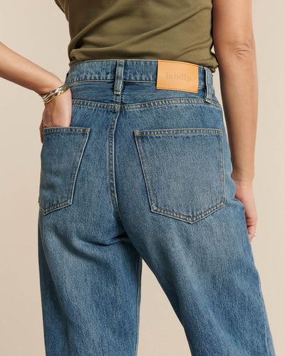Jean en denim bleu moyen avec coupe droite et taille haute, 100% coton, offrant un confort et une élégance décontractée pour femme.