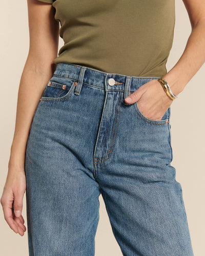 Jean droit en denim bleu moyen 100% coton, coupe longue et ajustée à la taille pour un style confortable et féminin adaptable à toutes les morphologies.