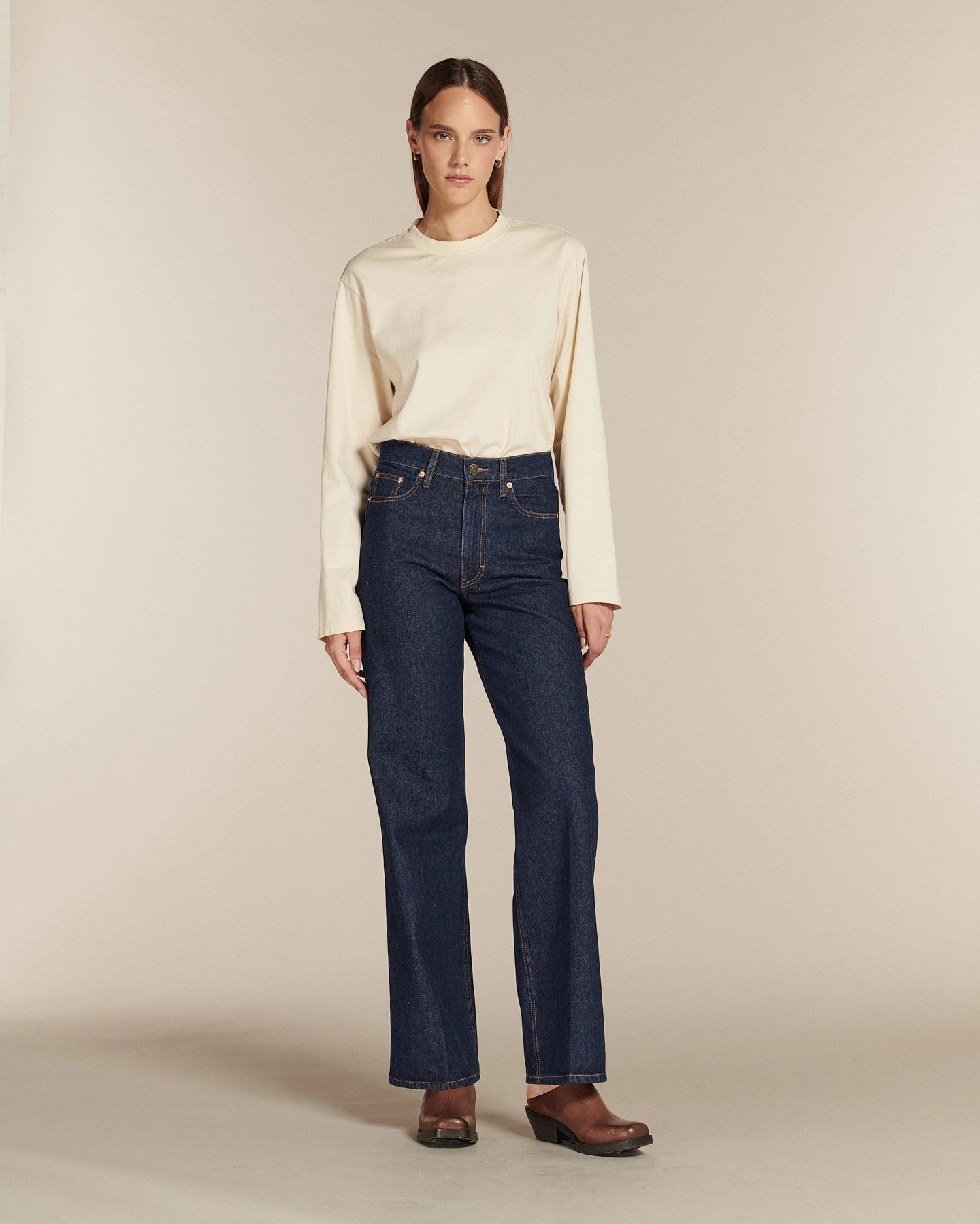 Jean droit long en denim brut 100% coton, taille haute, ajusté à la taille et aux hanches, avec une coupe qui s’adapte aux morphologies en X, V, et H.
porté par le mannequin de face