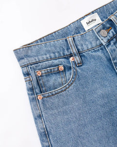 Jean en denim bleu clair 100 % coton avec coupe droite adaptée à toutes les morphologies féminines, finition soignée avec rivets cuivrés.