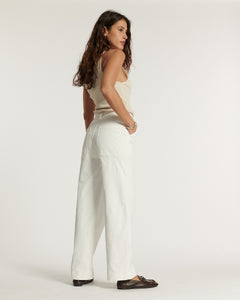 Jean blanc en coton avec coupe droite et taille haute, offrant un tombé ample et fluide adapté à toutes les morphologies féminines.