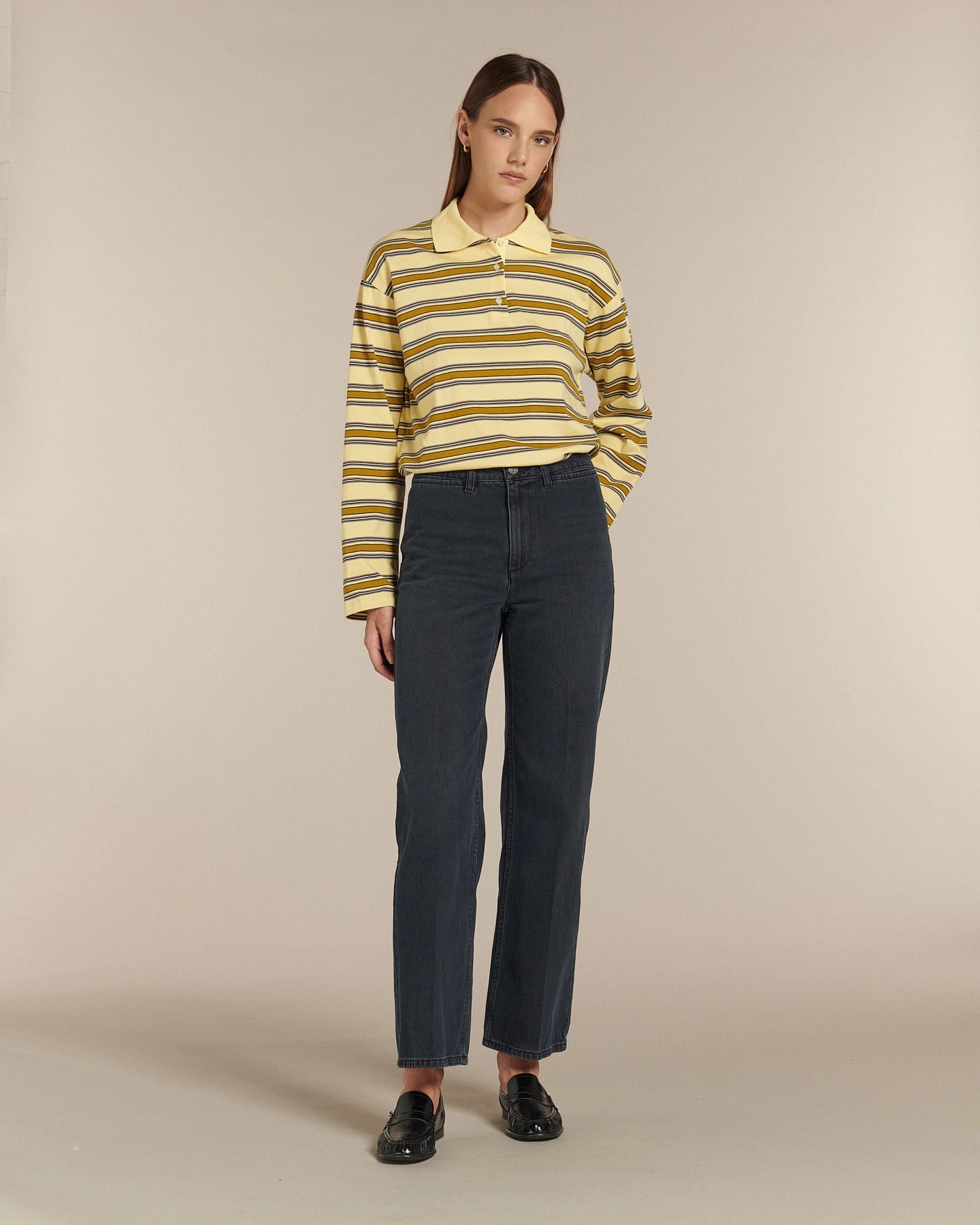 Jean droit en denim bleu foncé 100 % coton avec taille haute, coupe ajustée et matière légèrement rigide adaptée à toutes les morphologies féminines.