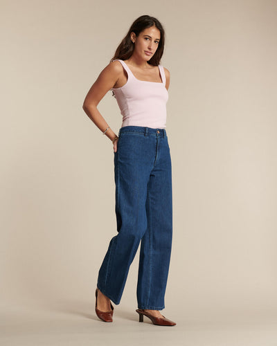 Jean en denim bleu moyen, coupe droite et taille haute, en coton dense offrant un tombé fluide et un ajustement confortable pour toutes morphologies.