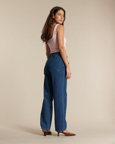Jean femme en denim bleu moyen, coupe droite et fluide, matière 100 % coton, conçu pour s’adapter à toutes les morphologies avec un style intemporel et confortable.