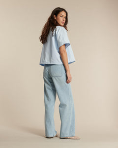 Jean femme en denim léger bleu clair, coupe droite et fluide, matière 100% coton confortable adaptée à toutes les morphologies.
