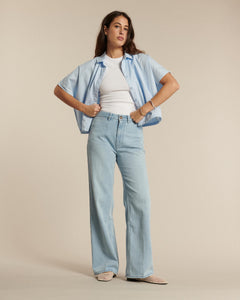 Jean en denim léger bleu clair, coupe droite et fluide, ajustement confortable et matière 100 % coton adaptée à toutes les morphologies féminines.