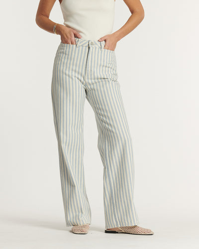 Jean droit pour femme en coton à rayures bleu clair et blanc, coupe taille haute offrant un ajustement flatteur adapté à plusieurs morphologies, idéal pour l'été.